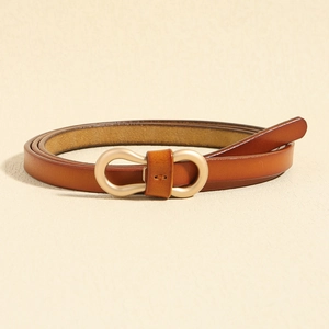Detail of slim brown leather belt with matte gold double-ring buckle on beige background