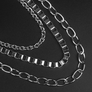 Macro detail of three silver metal chains with oval links and box chain textures