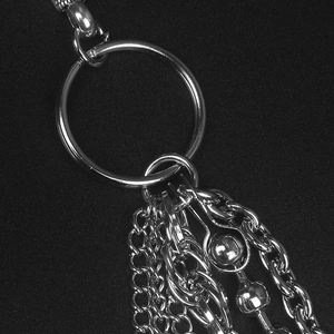 Macro shot of polished silver metal ring with multi-layered fringe chains on black background