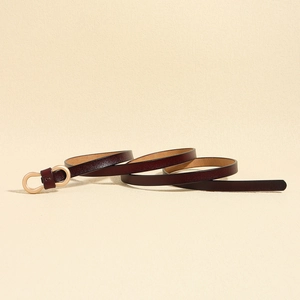 Close-up of slim dark brown cowhide leather belt with brushed gold U-shaped buckle