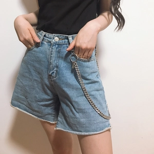 Detail of silver metal waist chain on light blue denim shorts with frayed hems