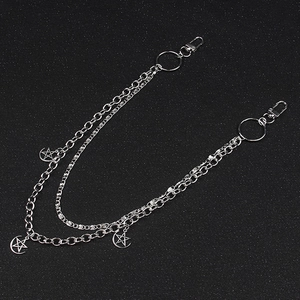 Détail d'une chaîne de pantalon double couche en métal argenté avec pendentifs étoile