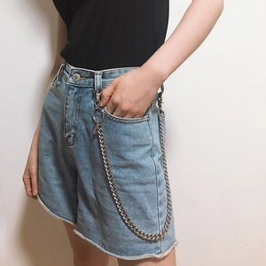 Detail of silver punk hip-hop waist chain with lobster clasps on denim shorts