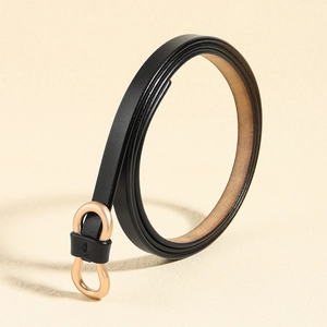 Close-up of thin black leather belt featuring a golden figure-eight alloy buckle