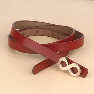 Close-up of a red leather women belt with a minimalist golden infinity buckle clasp
