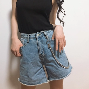 Detail of silver metal pants chain on light blue denim shorts with distressed edges