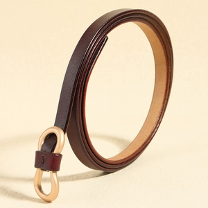 Detail of slim dark brown leather belt for women with elegant golden double ring buckle