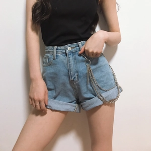 Detail of three-layer silver metal chains with rings and beads on denim shorts