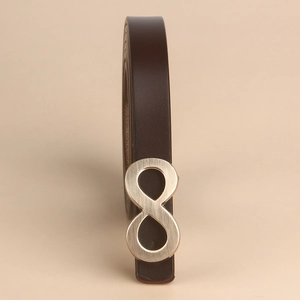 Detailed macro view of dark brown leather texture with golden figure-eight metal buckle