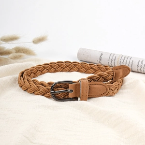Vintage brown woven belt for women with a round metal buckle on a rustic fabric background