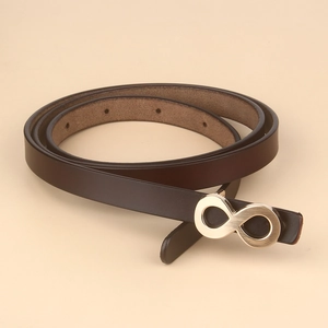 Detailed close-up of dark brown leather belt featuring a polished gold infinity buckle