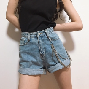 Close-up of triple-layered silver chains on high-waist denim shorts with cuffed hems