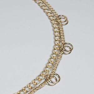 Close-up of double-layer gold geometric body chain with curb link and round pendants