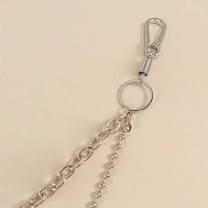 Close-up of industrial silver metal layered pant chain with carabiner and bead details