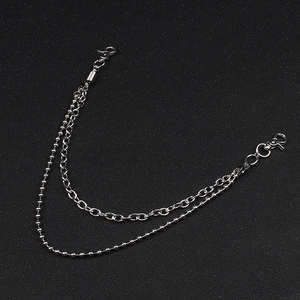 Detail of silver layered metal pant chain featuring flat oval links and ball chain texture