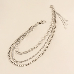 Detail of silver multi-layered metal trousers chain with star pendants and lobster clasps