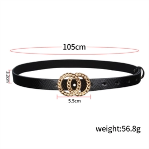 Detailed view of black faux leather belt with golden double O-ring buckle and textured embossing