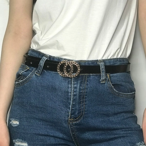 Women's black leather belt with gold double-O ring buckle on jeans for casual style