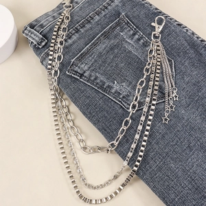 Detail of silver multilayer metal hip hop pant chain with star pendants on denim