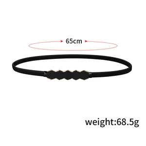 Detail of slim black elastic belt with golden hexagonal buckle and 65cm size mark