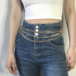 Close-up of triple-layered golden waist chain with rhinestones on high-waisted jeans