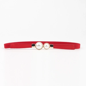 Détail d'une fine ceinture élastique rouge avec boucle élégante à double perle blanche