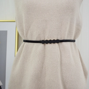 Women's thin black waist belt featuring a geometric gold-trimmed hexagonal buckle