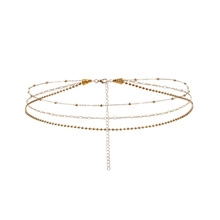 Detailed close-up of a three-layer gold waist chain with delicate bead drops and extension