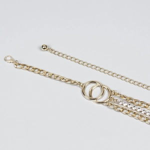 Detailed close-up of a gold multi-layer chain belt with sparkling rhinestones and rings