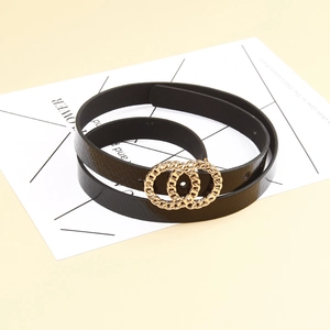 Close-up of black leather belt with golden double O-ring buckle and chain texture