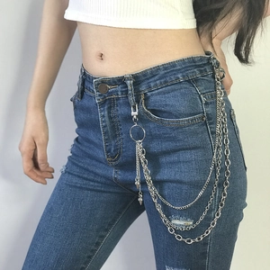 Détail de chaînes de pantalon argentées multicouches avec rivets et pendentifs coniques