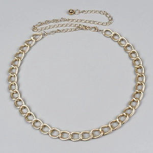 Close-up of golden twist chain link with adjustable extender and metallic bead drop
