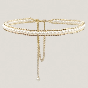 Detail of elegant gold-tone chain waist belt with integrated white pearls and pendant