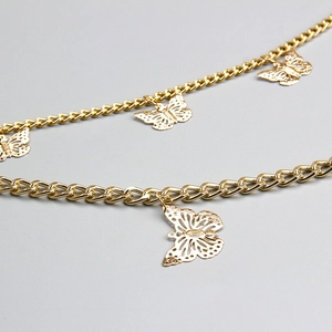 Detail of gold layered chain with hollow butterfly pendants and thick Cuban links