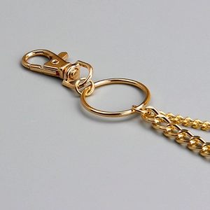 Detailed close-up of polished golden double-layered pant chain with lobster clasp and ring