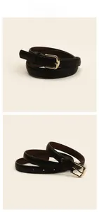Détails d'une ceinture fine en cuir noir avec boucle dorée et trous réglables