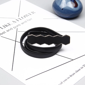 Close-up of black elastic spring belt featuring triple hexagonal geometric buckles
