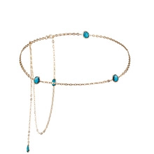 Detailed close-up of golden spring waist chain with blue teardrop gemstone pendants