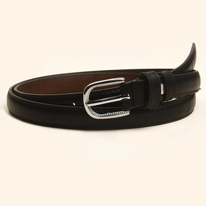 Détail d'une ceinture fine en cuir noir pour femme avec boucle en U argentée polie