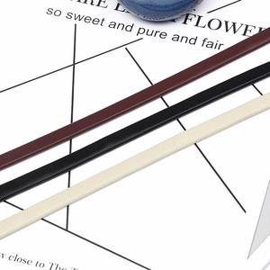 Detail shot of elastic spiral waist belts in black, dark brown, and off-white colors