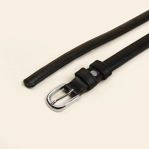 Vue détaillée d'une ceinture fine en cuir noir avec boucle en fer à cheval argentée polie