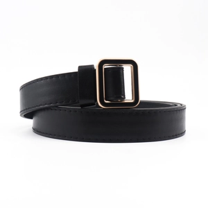 Détail d'une ceinture en cuir noir avec boucle carrée dorée et coutures de précision