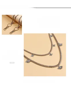 Detail of silver bee and butterfly charms on a double-layered punk style trousers chain