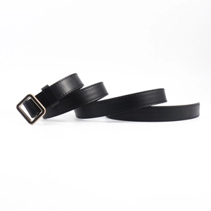 Détail montrant la texture du cuir noir et la boucle carrée dorée sur une ceinture fine
