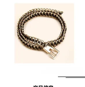 Detail of woven black PU leather with layered gold metal chunky chain waist belt
