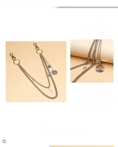 Detail of multi-layer metal pants chain with lightning bolt and round letter pendants