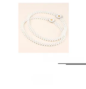 Détail d'une chaîne de taille élastique en perles avec deux décorations de marguerites