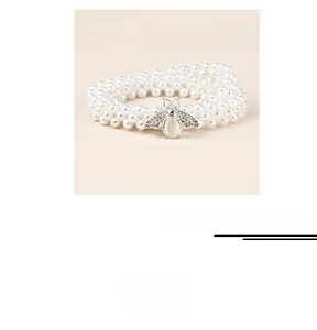 Vue détaillée de la chaîne de taille en perles avec boucle abeille en argent et strass