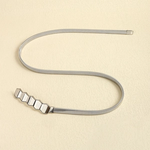 Detail of silver metallic spring belt with polished hexagonal geometric buckle design