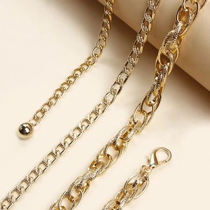 Chaîne de taille dorée à double rangée avec divers maillons et pendentif boule métallique
